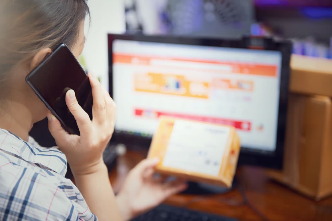 Warehouse coordinator checking customer delivery address and contact details before dispatch
