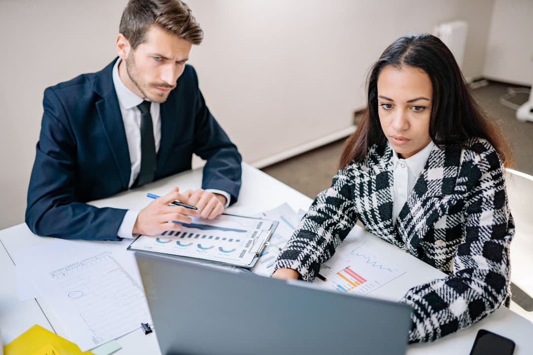 Finance reviewer and sales manager checking the final amount of a revised quotation